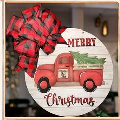 a red truck with a christmas tree on it is hanging from a wooden sign that says merry christmas