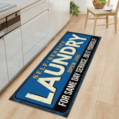 a blue and white laundry sign sitting on top of a wooden floor in a kitchen