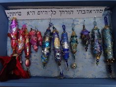 an assortment of ornaments hanging from hooks in a blue box with writing on the wall