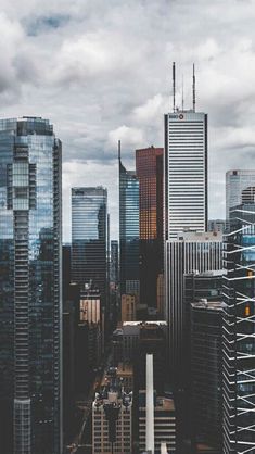 an aerial view of skyscrapers and other tall buildings in the city with cloudy skies