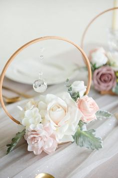 a close up of a flower decoration on a table with flowers in the middle and gold rim