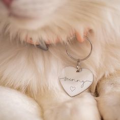 a close up of a dog's name on a heart shaped keychain