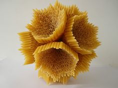 three pieces of pasta are arranged in the shape of an origami sunflower