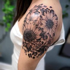 a woman's shoulder with black and white flowers on her left half - sleeve