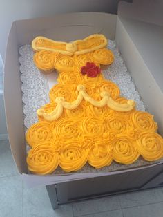 a cake in the shape of a princess's dress with yellow icing on it