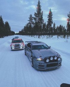 two cars driving down a snow covered road