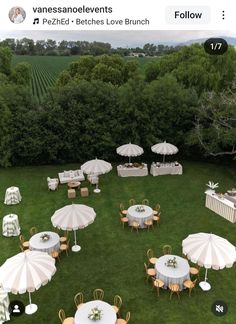 an aerial view of tables and umbrellas set up in the middle of a field