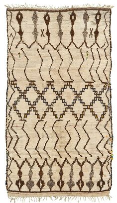 an old rug with brown and white designs on it's edges, including fringes