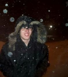 a woman wearing a black jacket and fur hat in the snow with bubbles coming out of her eyes