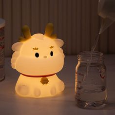 a little light that is sitting next to a jar and some bottles on a table