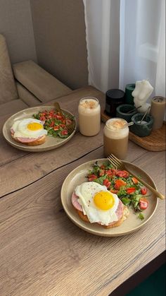 two plates filled with food sitting on top of a wooden table next to a window