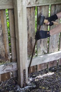 a person with gloves on is using a fence tool