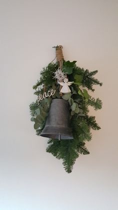 a bell hanging from the side of a wall with greenery on it's sides