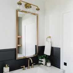 a white sink sitting under a bathroom mirror next to a faucet mounted on a wall