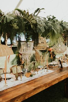 an outdoor table set up with wicker chairs, palm trees and other items on it