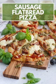 sausage flatbread pizza with basil and cheese on cutting board next to fresh basil leaves