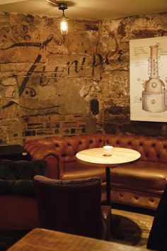 a living room filled with brown leather furniture and a painting on the wall behind it