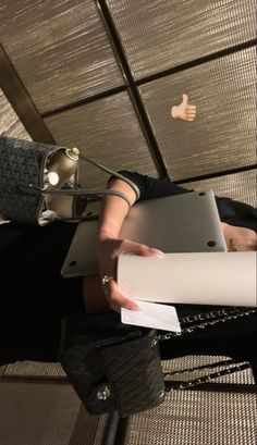 a woman sitting on a chair holding a laptop