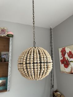 a chandelier made out of wooden beads hangs from the ceiling in a child's room