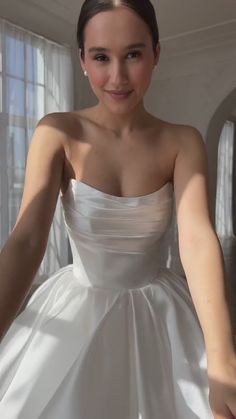 a woman in a white dress posing for the camera