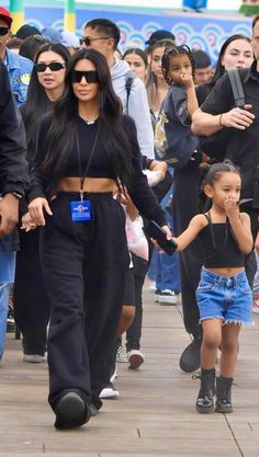 kim kardash and her daughter are seen walking down the street with other people