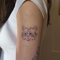 a woman's arm with a cat tattoo on the left side of her arm