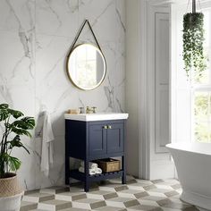 a bathroom with a sink, mirror and bathtub next to a potted plant