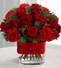 a vase filled with red flowers on top of a table