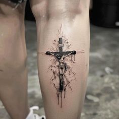 a tattoo on the leg of a person with a crucifix in it