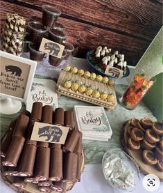 an assortment of desserts displayed on a table with brown paper wrappers and cookies