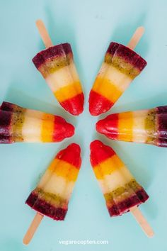 four popsicles are arranged in a circle on a blue surface