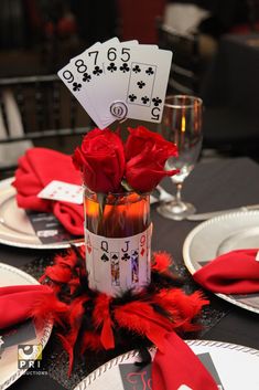 the table is set with cards and roses