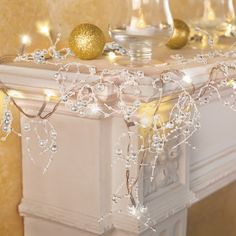 a white mantle with candles and ornaments on it