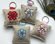 four keychains with embroidered flowers on them