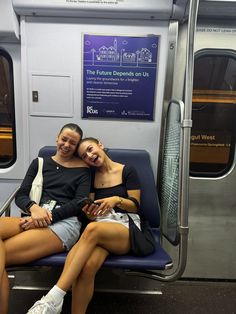 two young women sitting on a subway train