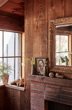 a room with wood paneling and a mirror on the wall next to a fire place