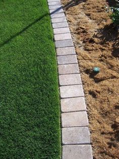 a brick walkway in the middle of some grass