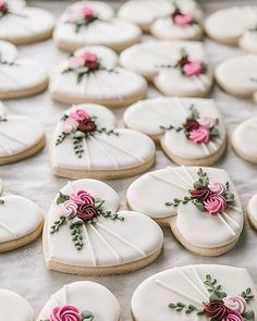 decorated heart shaped cookies on a table with pink and red flowers in the middle,