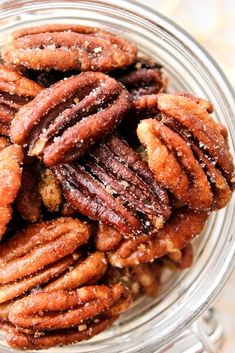 a glass bowl filled with pecans on top of a table