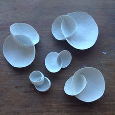 several white bowls and spoons on a wooden table