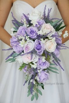 a bride holding a purple and white bouquet