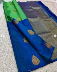 a blue and green saree laying on top of a bed