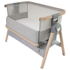 a baby crib that is made out of wood and has grey fabric on it