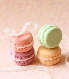 three macaroons sitting on top of each other next to a white cupcake