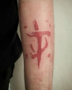 a man with a tattoo on his arm that has the letter f painted on it