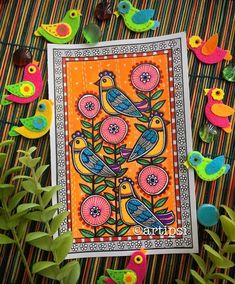 a card with birds on it surrounded by flowers and other colorful objects in the background