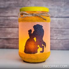 a mason jar with a silhouette of a man and woman on it, next to a wooden background