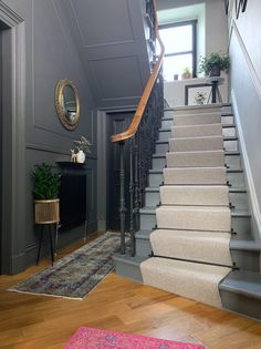 a staircase leading up to the second floor in a house with gray walls and wood floors