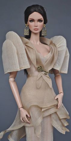 a mannequin wearing a beige dress and gold earrings