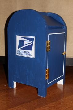 a blue mailbox sitting on top of a hard wood floor